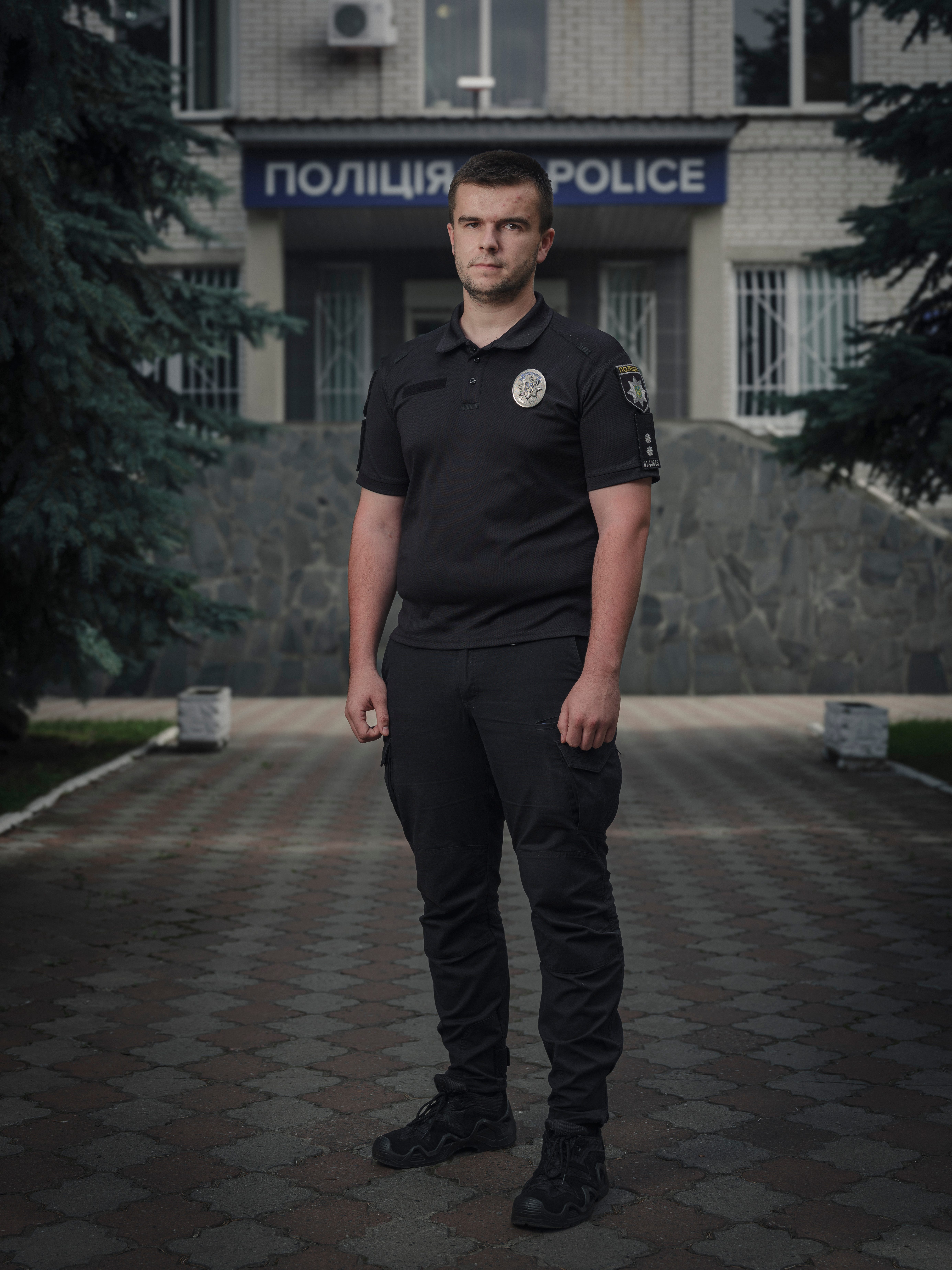 Maksym Kot, investigator in the Department for Investigating Crimes Against a Person's Life and Health stands for a portrait outside the Brovary District Police Department of the Main Department of the National Police.