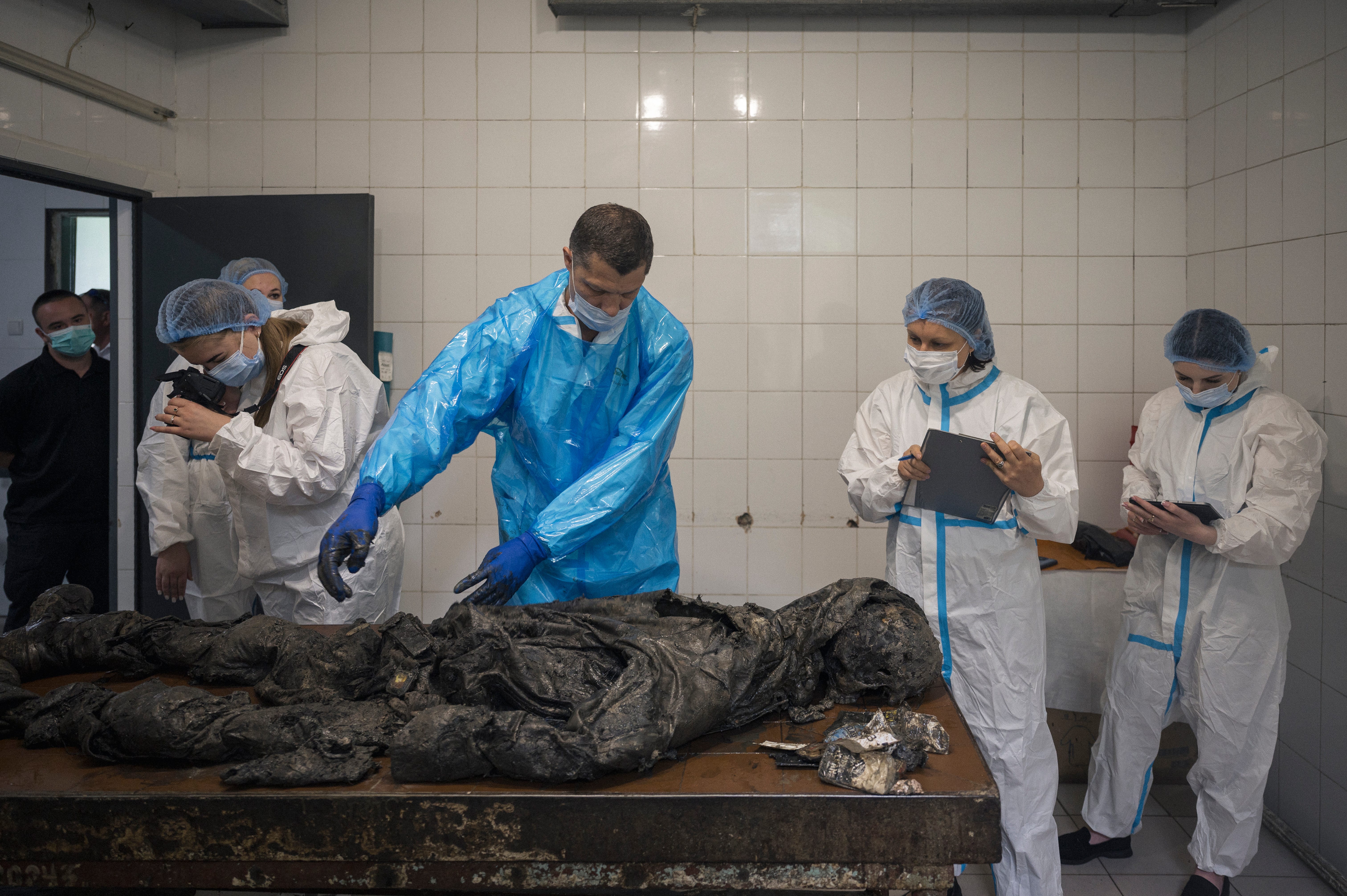 Forensic experts examine the remains of a Ukrainian soldier whose body was returned to the country in an exchange with Russian occupation forces.