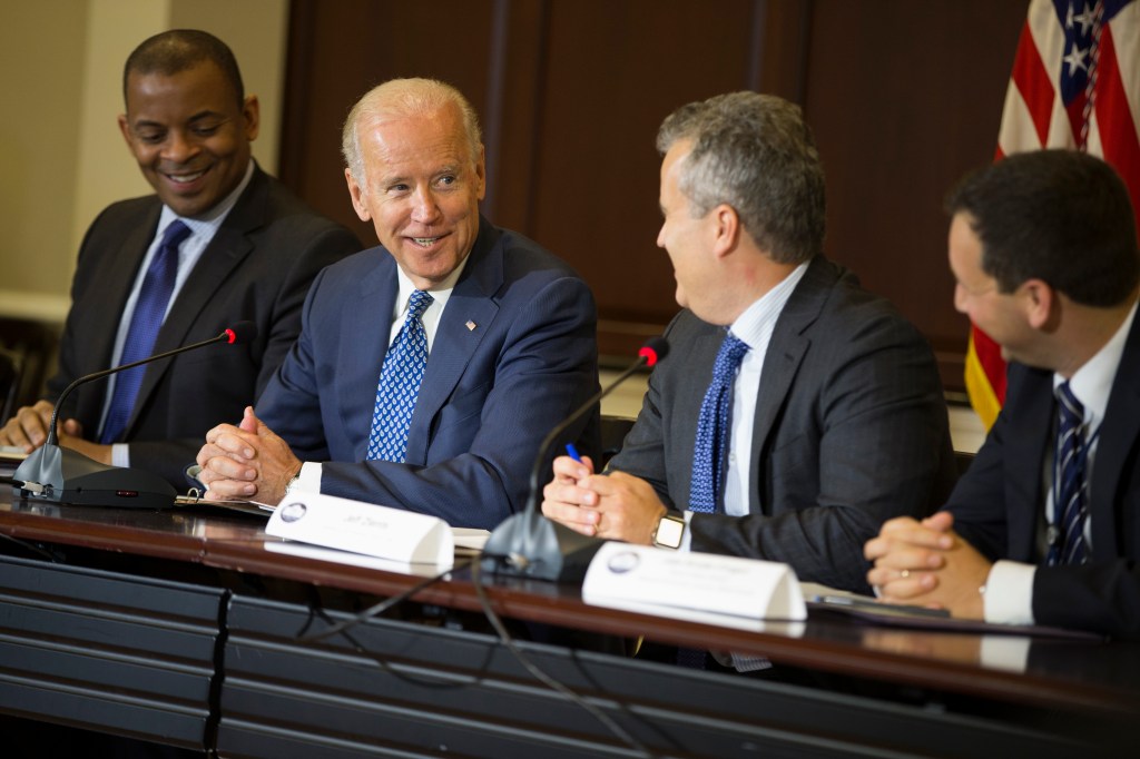 Joe Biden, Jeff Zients, and two other men seated at a table.