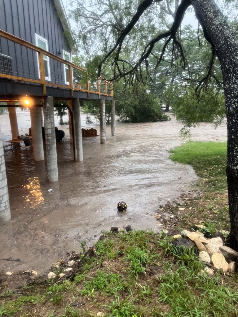Floodwaters surrounding a house on stilts.