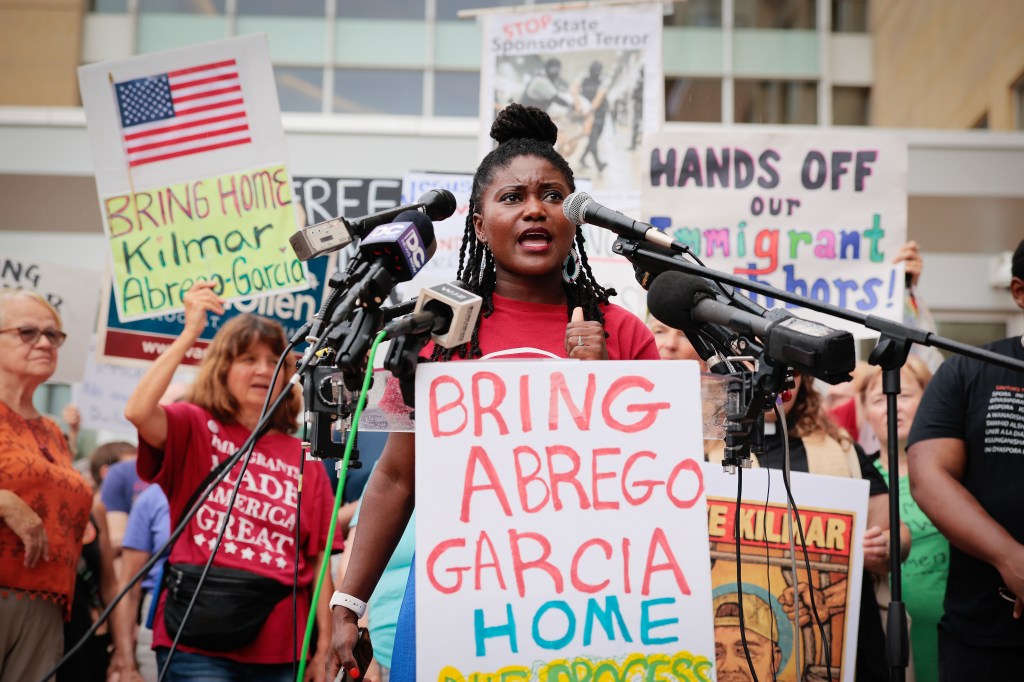 Woman speaking at a rally advocating for the return of Kilmar Abrego Garcia.