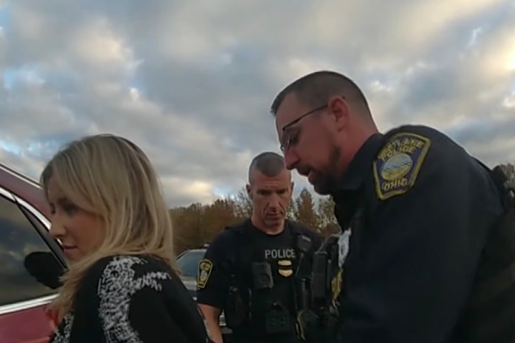 A woman being arrested by two police officers.