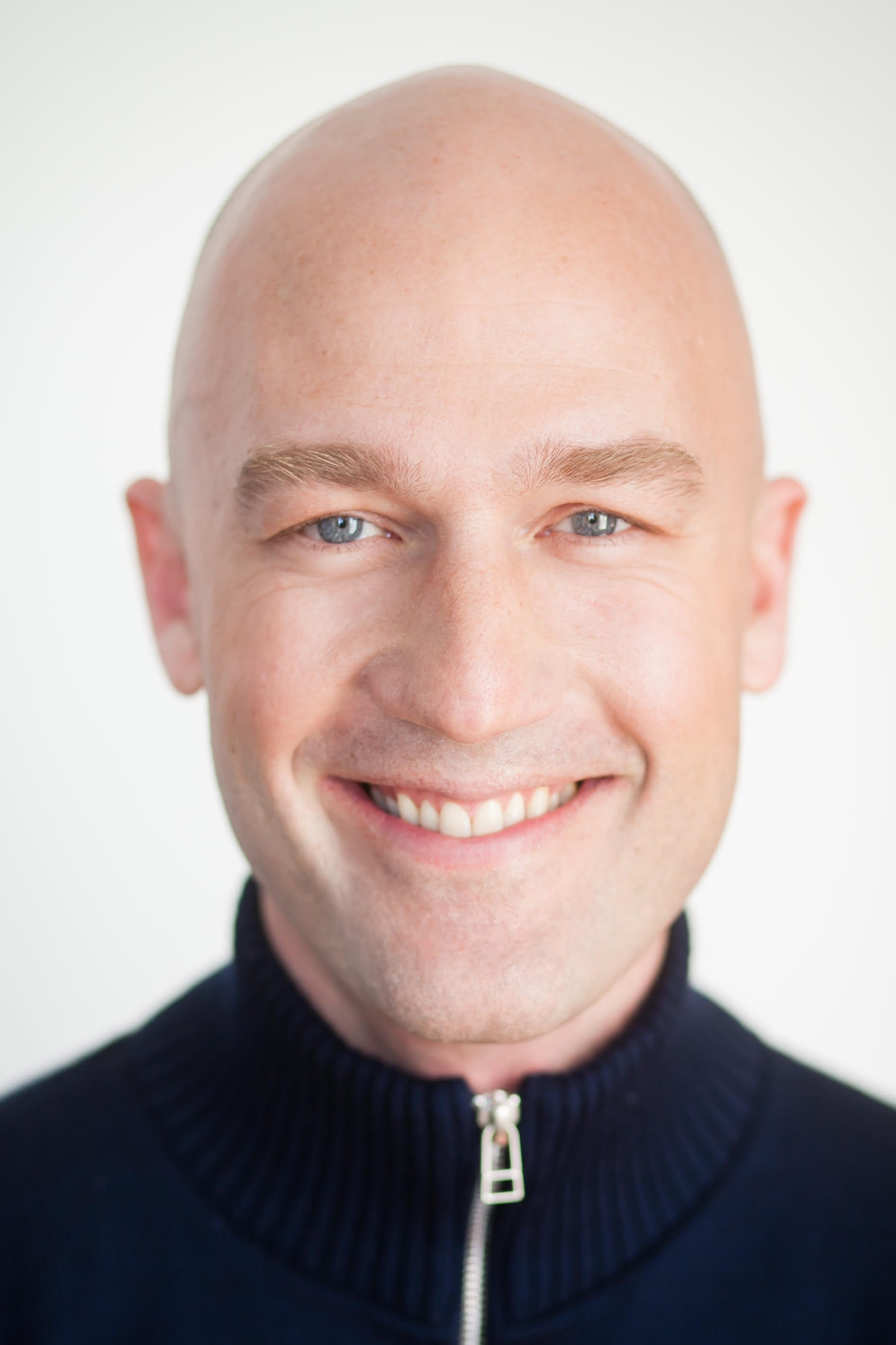 A portrait photo of a man smiling at the camera