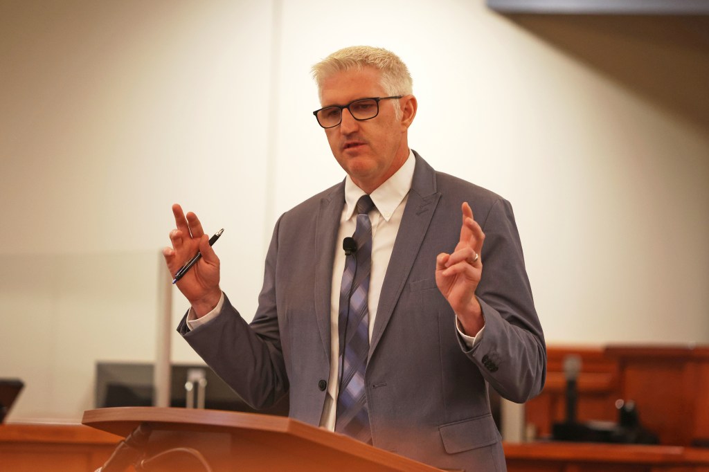 A man in a suit giving a presentation.