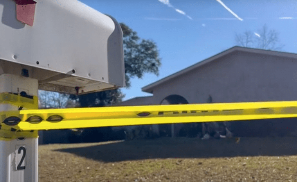 Crime scene tape across a yard.