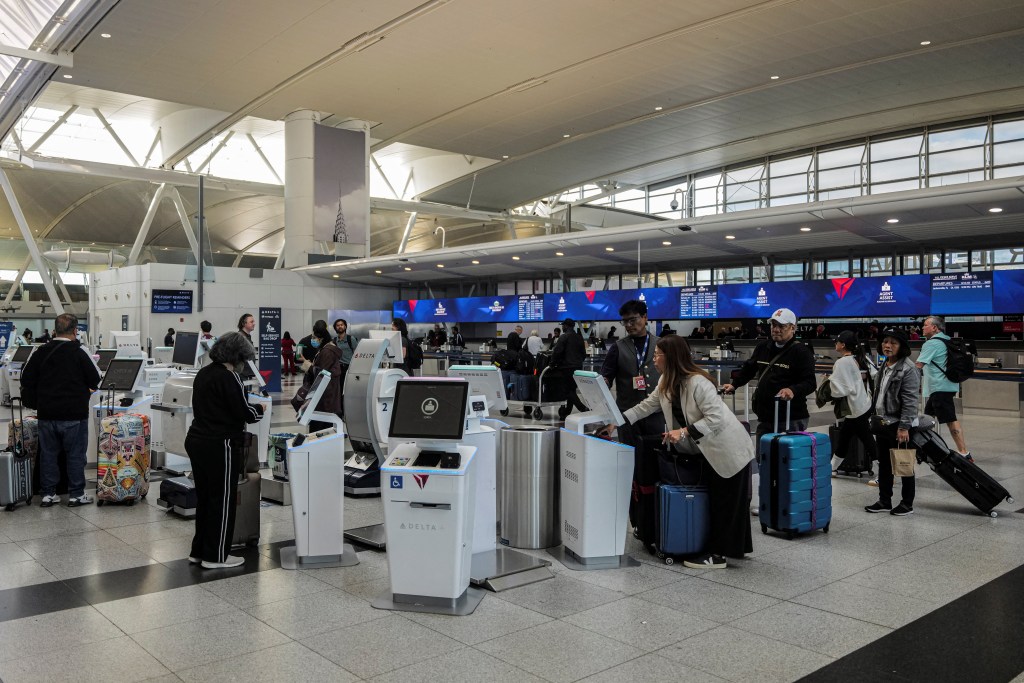 Passengers checking in at a Delta Airlines counter at JFK Airport.