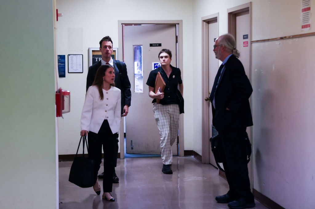 Four people walking down a hallway.