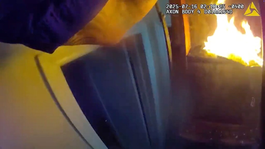 NYPD officers entering a burning building.