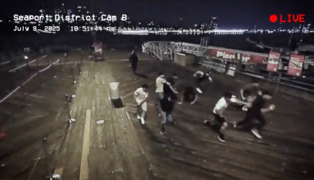 Screenshot from surveillance video showing mysterious cloaked man, carrying a sickle, scaring group of nine teen boys on South Street Seaport