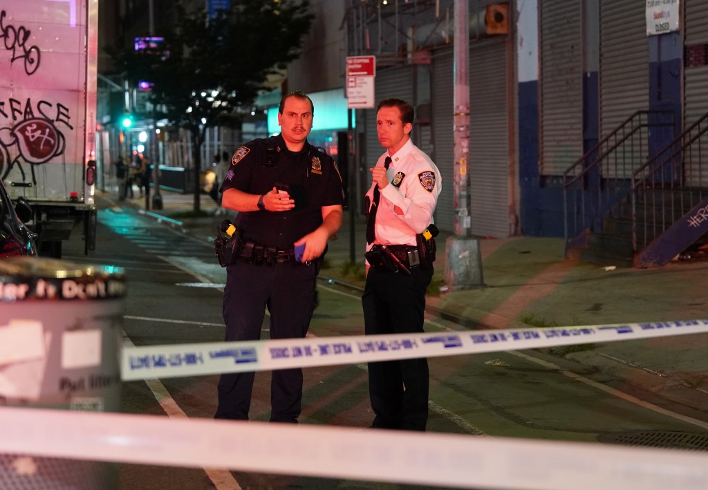 Two NYPD officers at a crime scene.