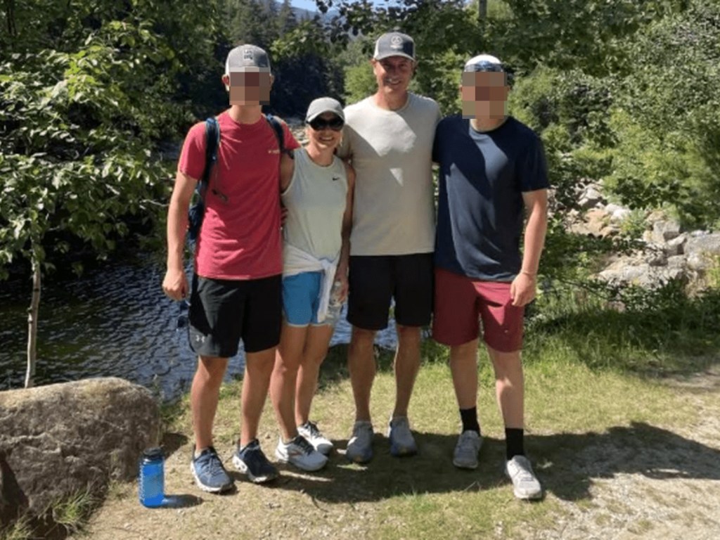 Photo of a family of four by a river.  Faces are blurred.