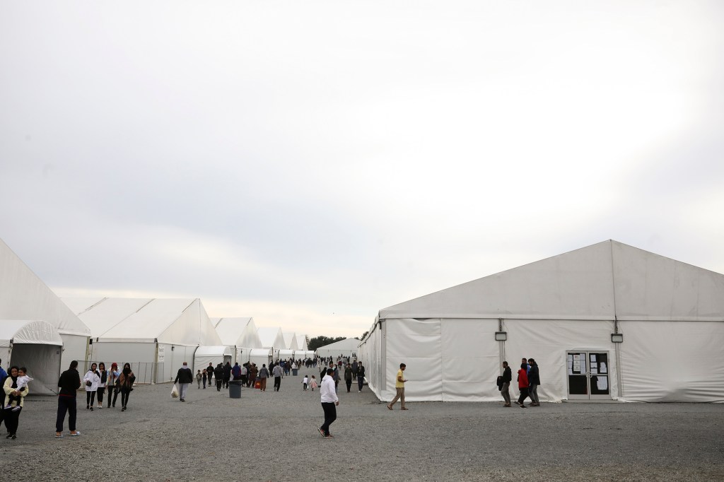 Afghan refugees walking outside a temporary housing facility.