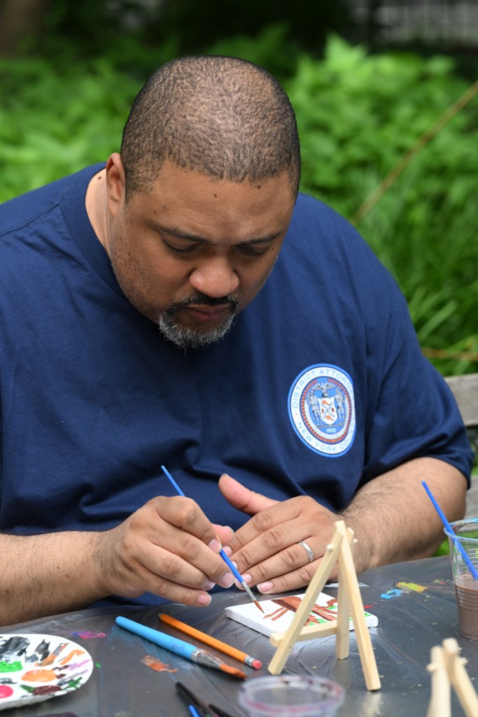 Alvin Bragg painting a tree.