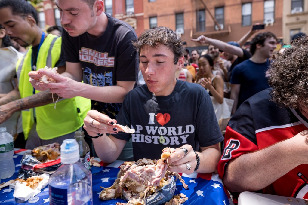 People eating chicken at a competition.