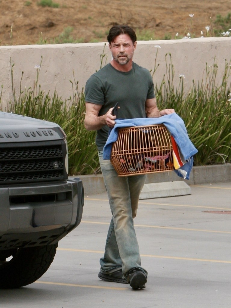 Aaron Phypers walking while holding a dog cage.