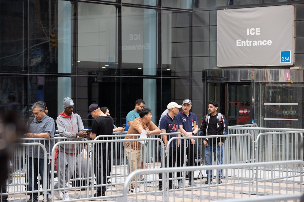 Migrants waiting to enter an ICE entrance.