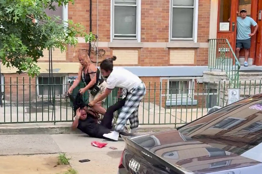 Two women assaulting a woman on the ground.