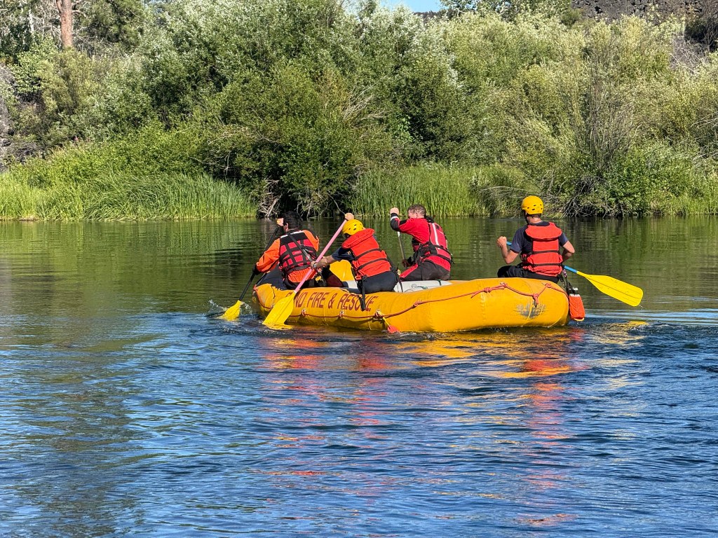 Rescue workers in a raft on a river.