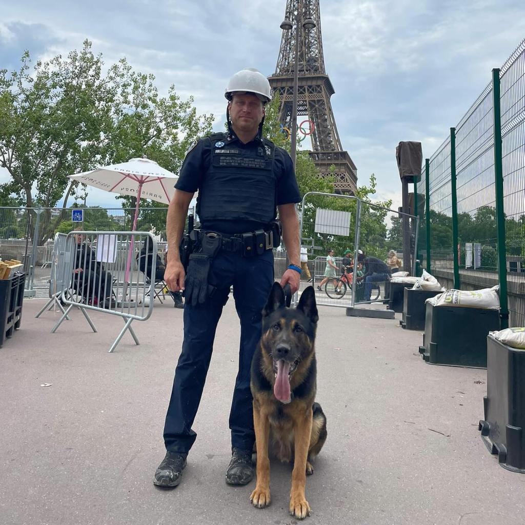NYPD officer and K9 in Paris near the Eiffel Tower.