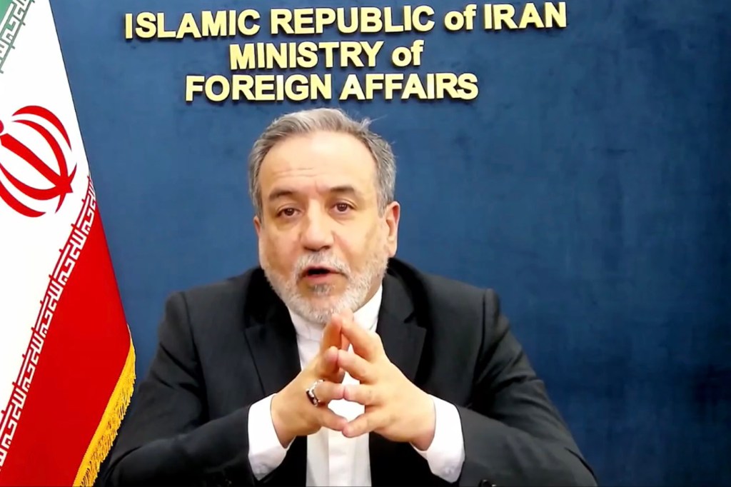 Iranian official speaking in front of the Ministry of Foreign Affairs sign.