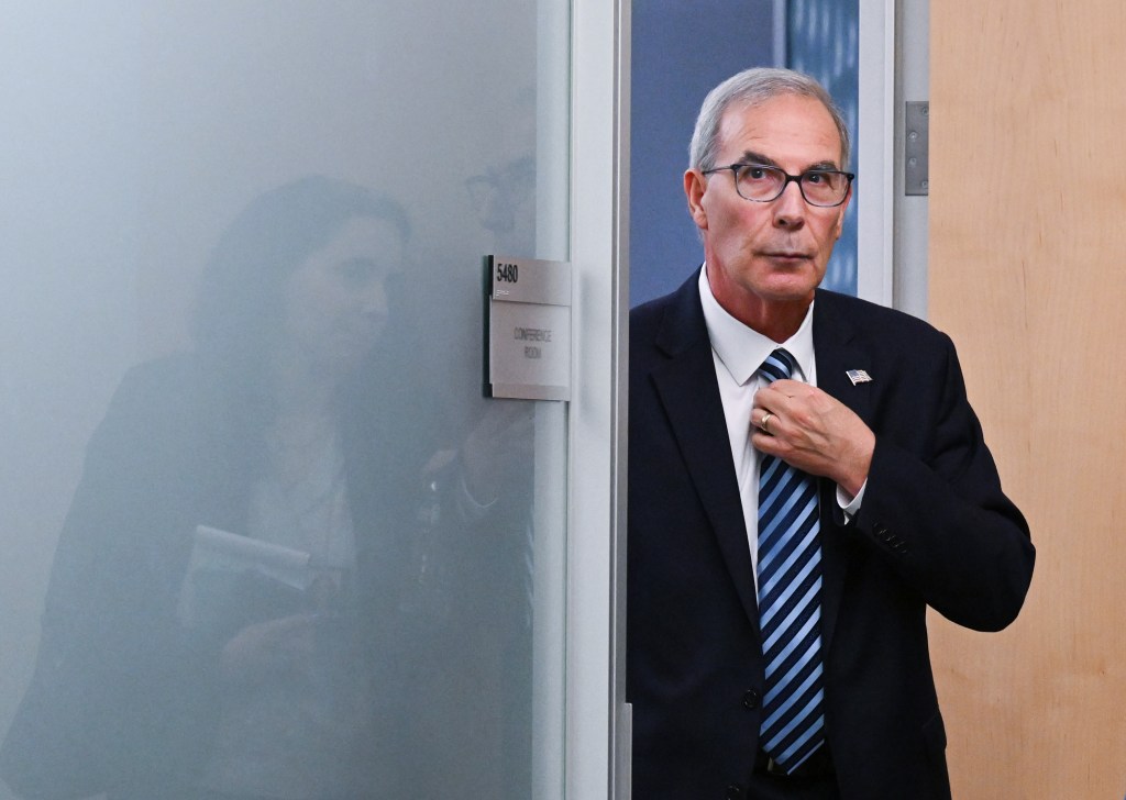 Photo of David Weiss leaving a meeting.