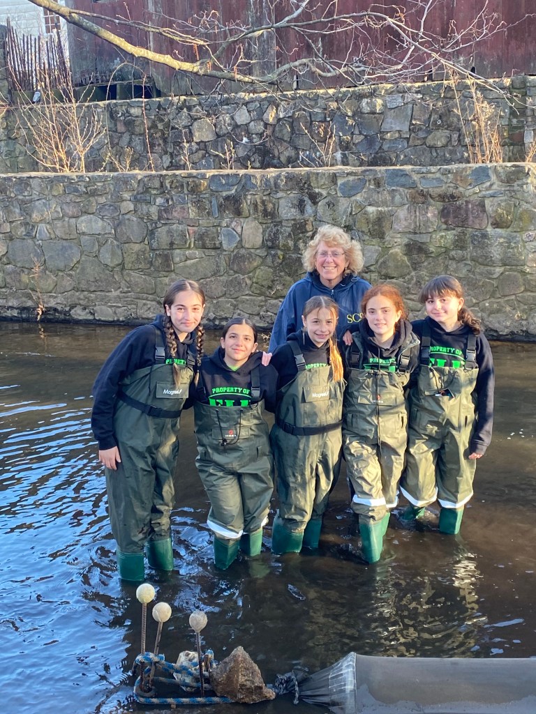 Mary Lee and her students stand in the creek.