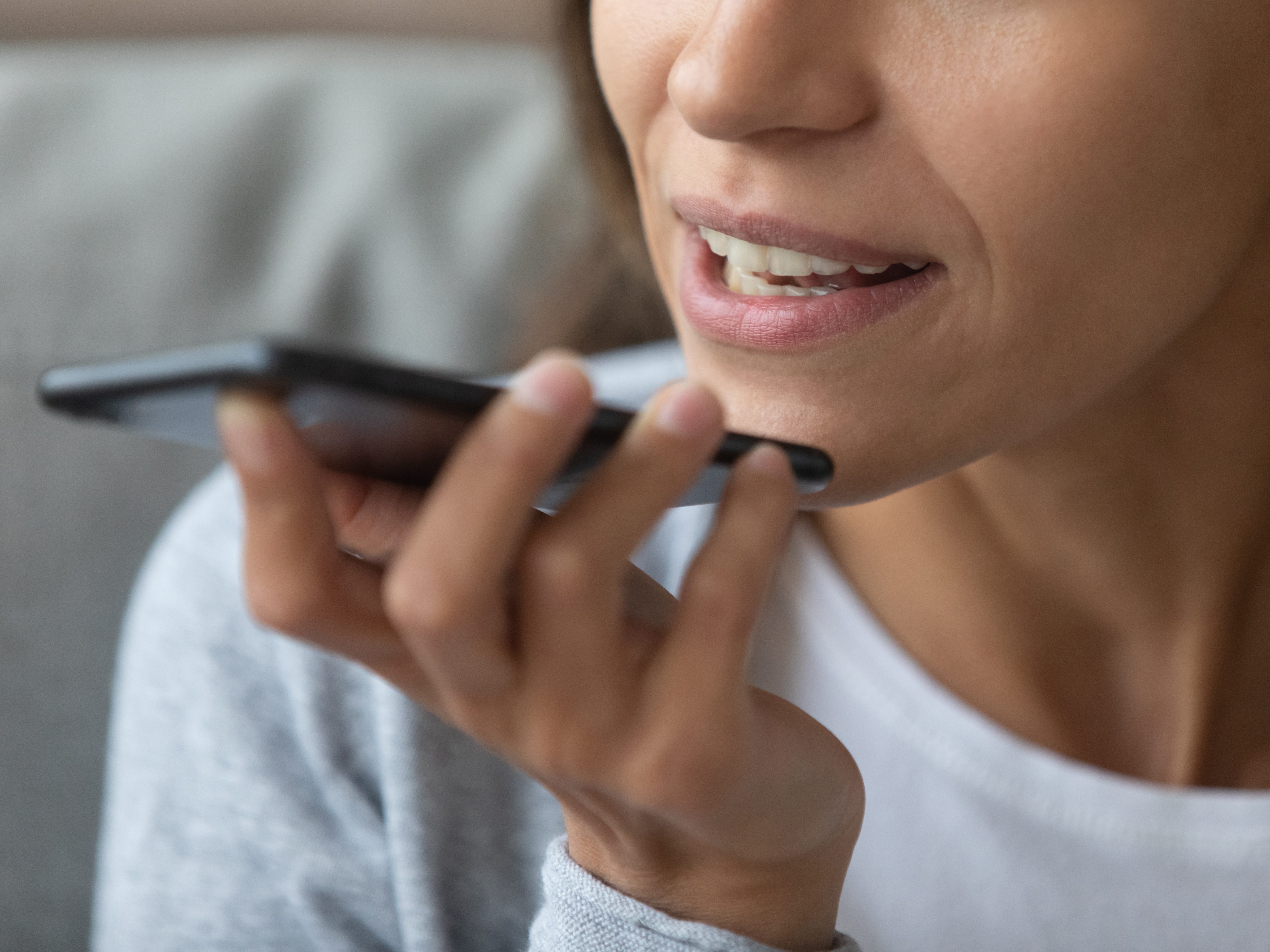 A close-up of a woman talking on speakerphone.