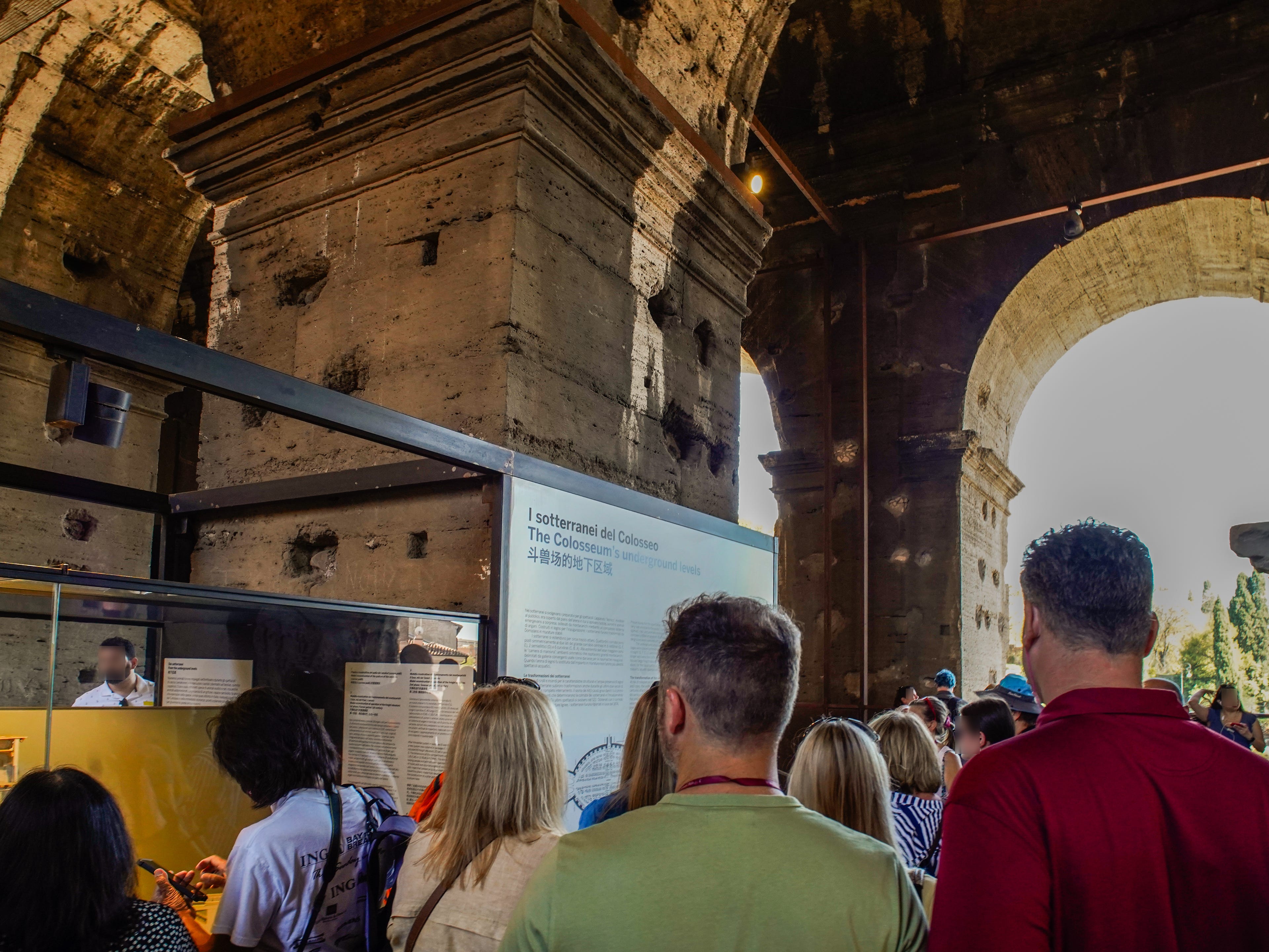 Crowds of people stand in front of exhibits at the Colosseum in Rome