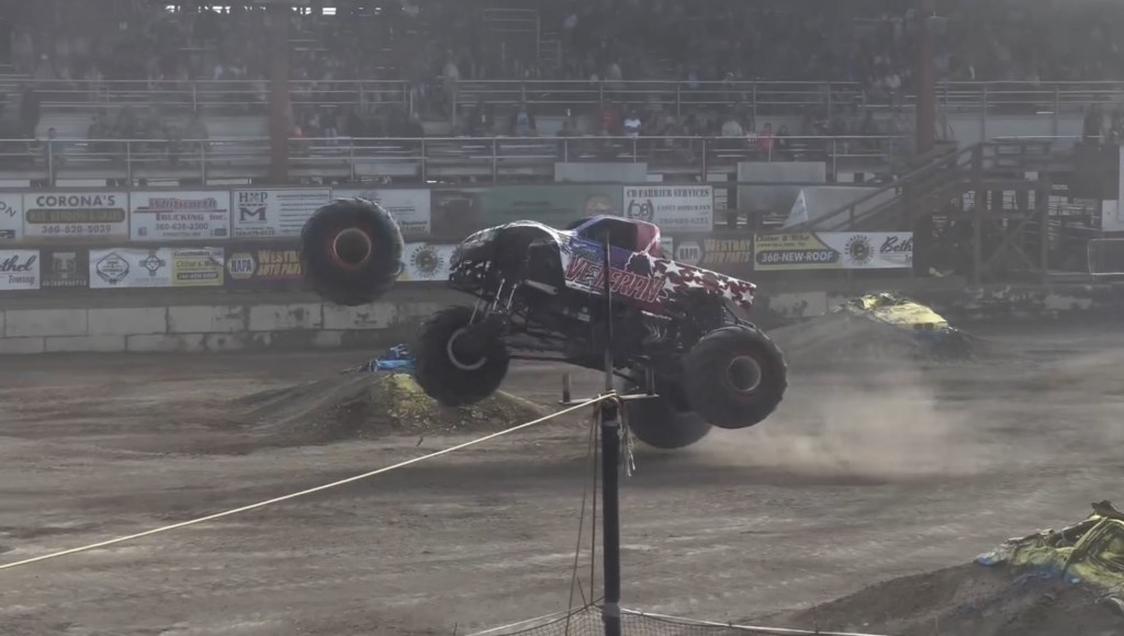 Monster truck performing a jump at an arena.