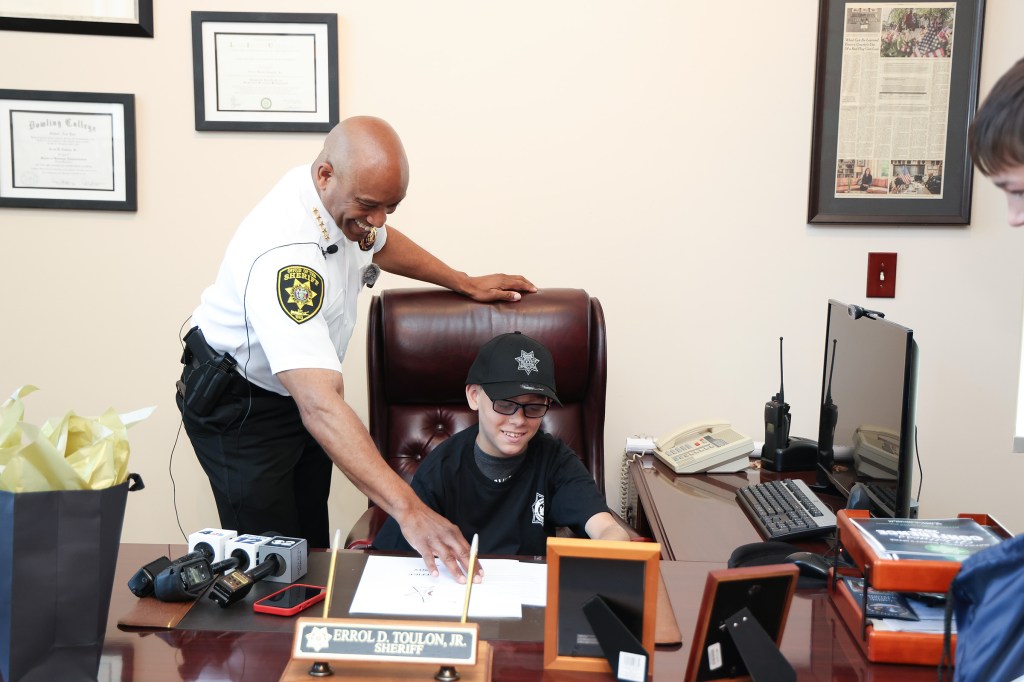 Sheriff Errol Toulon Jr. inducts a young boy as honorary sheriff for a day.
