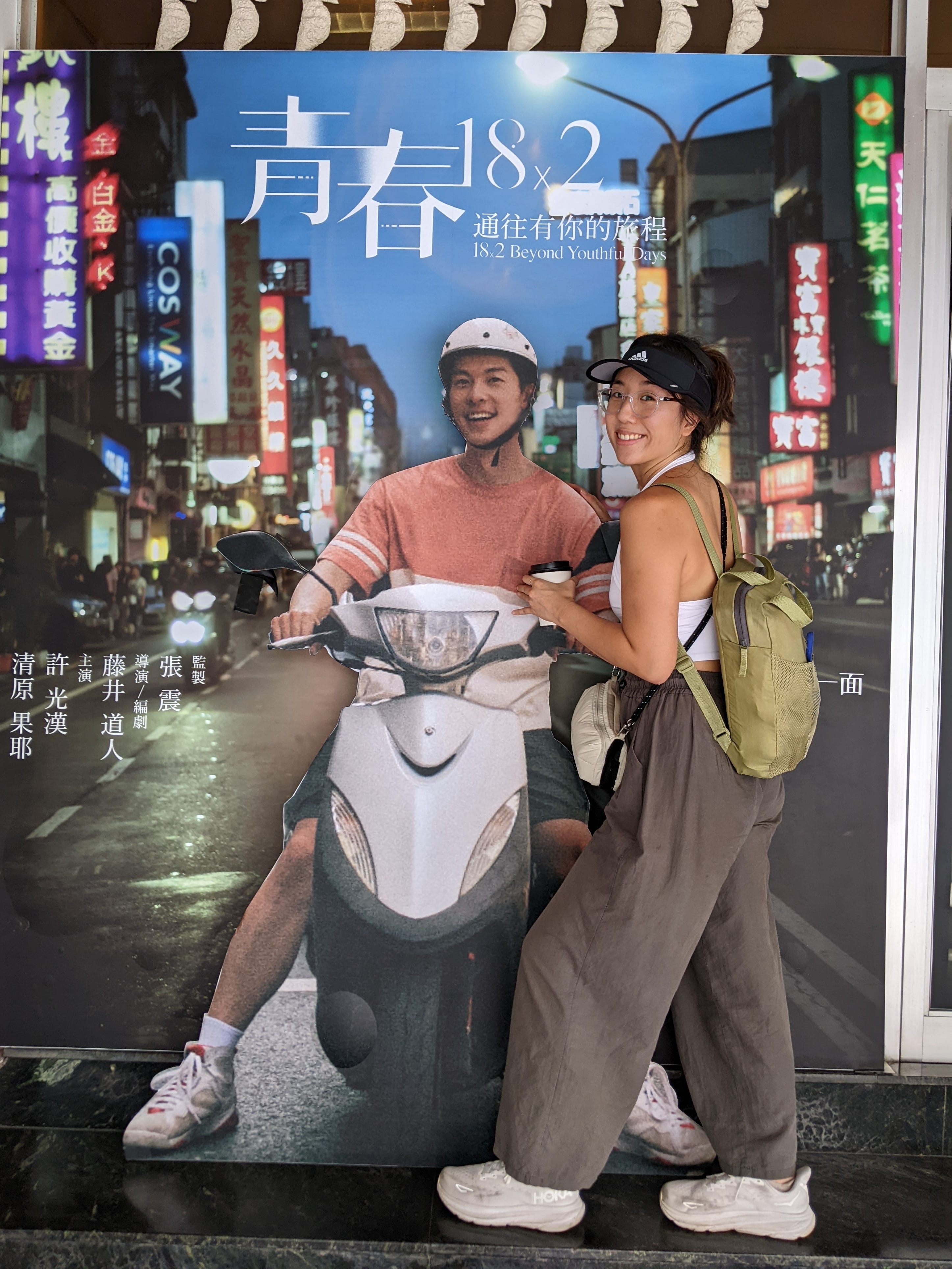Ginny Wu is posing with a movie poster of a famous Taiwanese actor.
