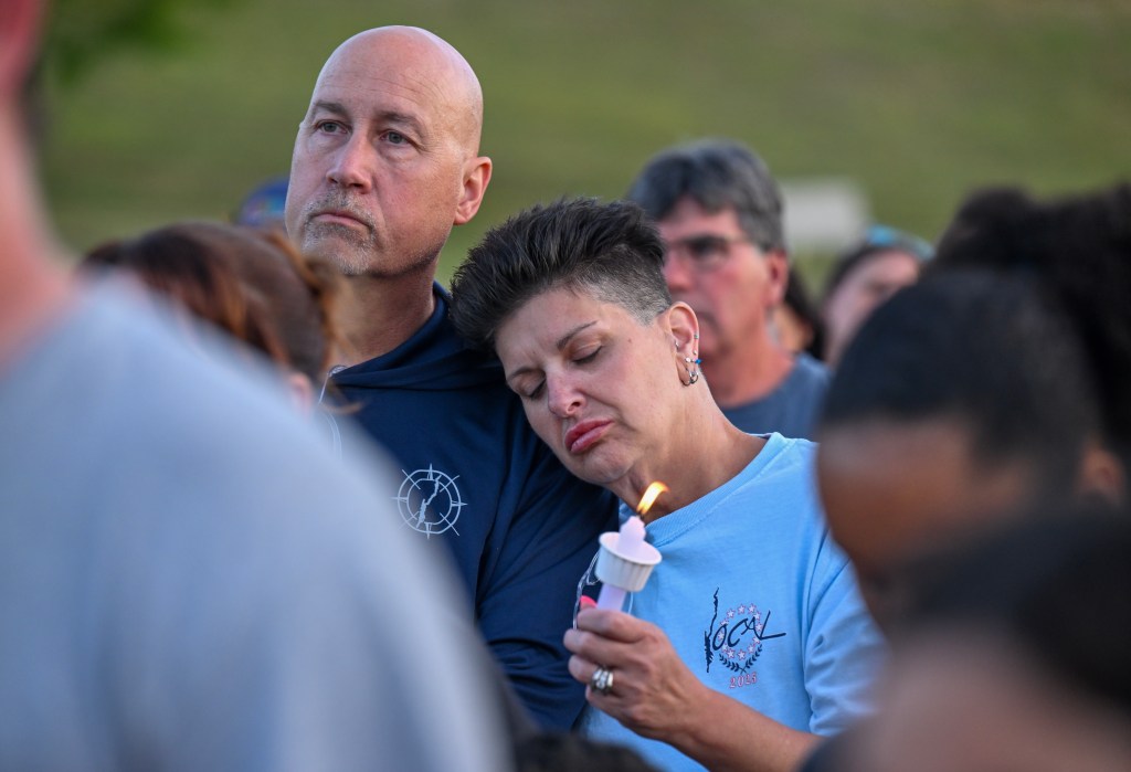 A couple mourns the 9-year-old girl during the candlelight vigil.