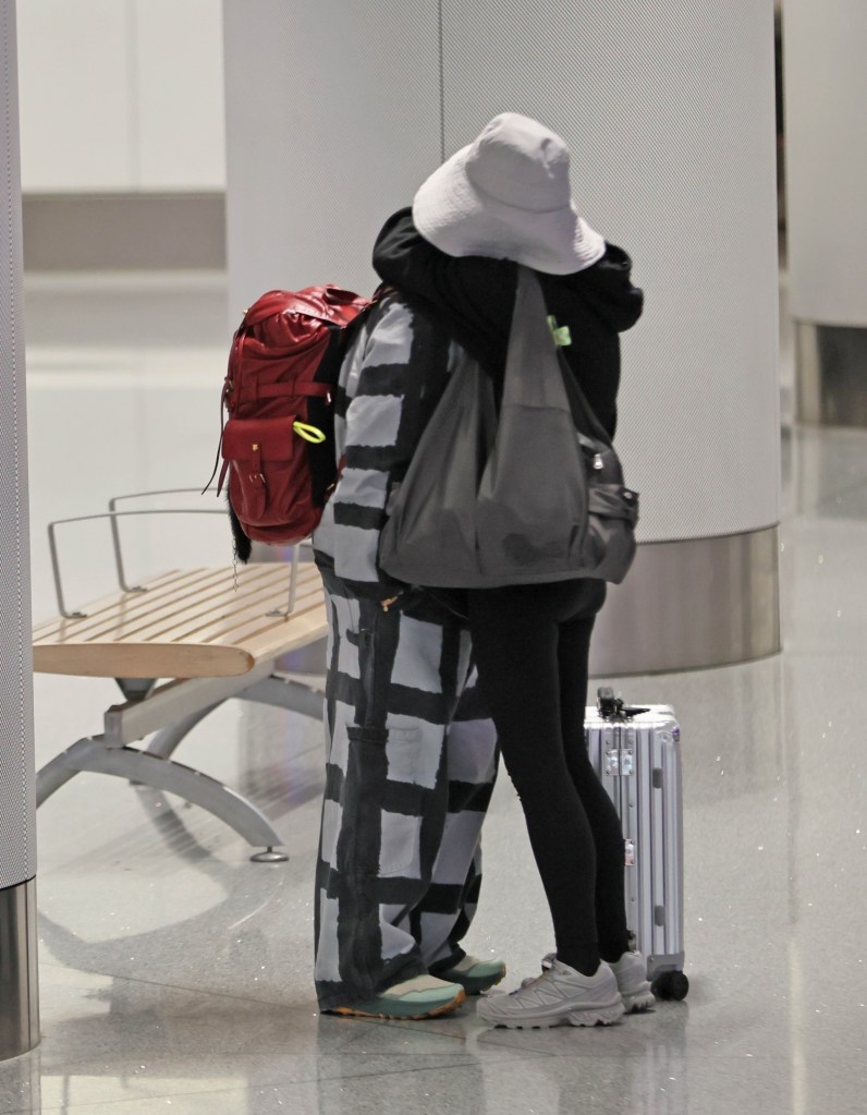 Raven-Symoné hugging her wife, Miranda Maday, at the airport.
