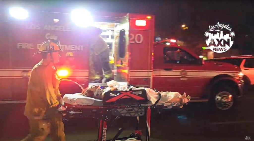A person is moved on a stretcher by a firefighter after a vehicle plunged into a crowd outside a nightclub, on Santa Monica Boulevard 