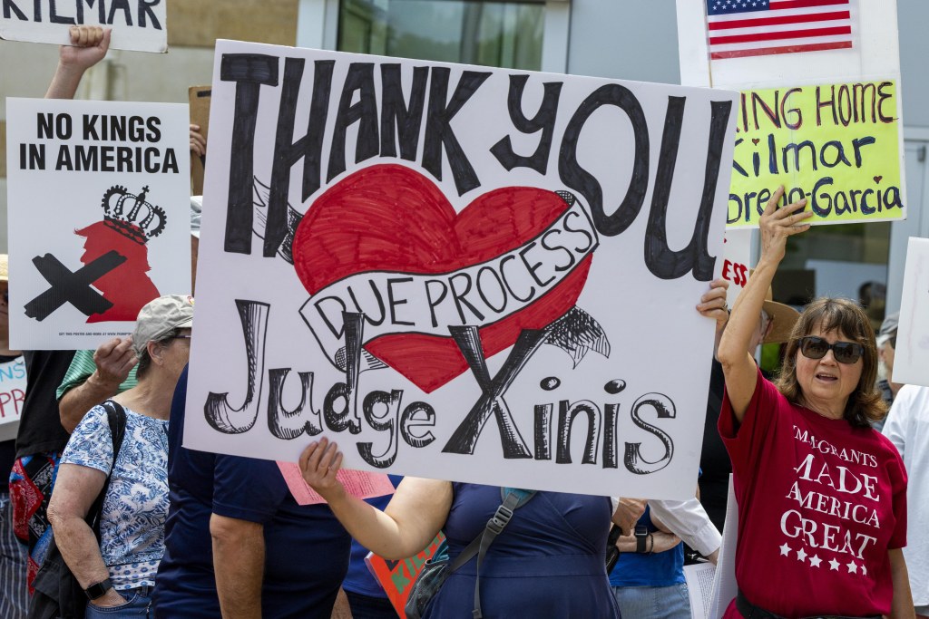 Protestors holding signs supporting Kilmar Abrego Garcia's return from El Salvador.