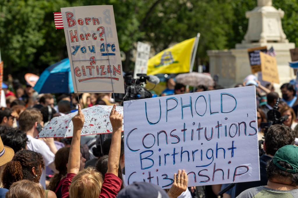 Protestors holding signs outside the Supreme Court regarding birthright citizenship.