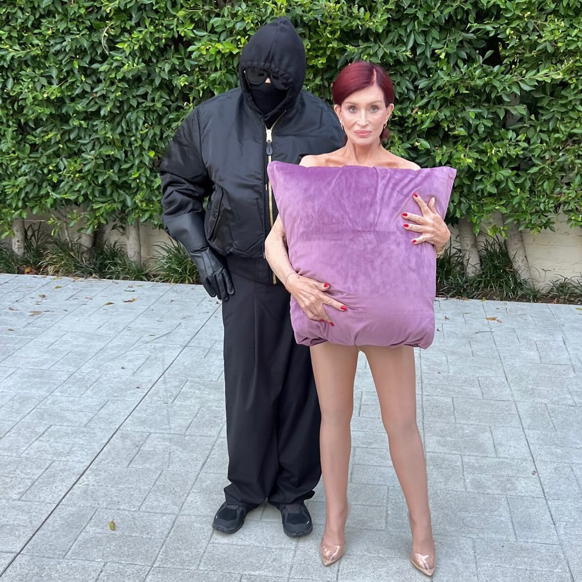 Ozzy and Sharon Osbourne wear costumes outdoors. 