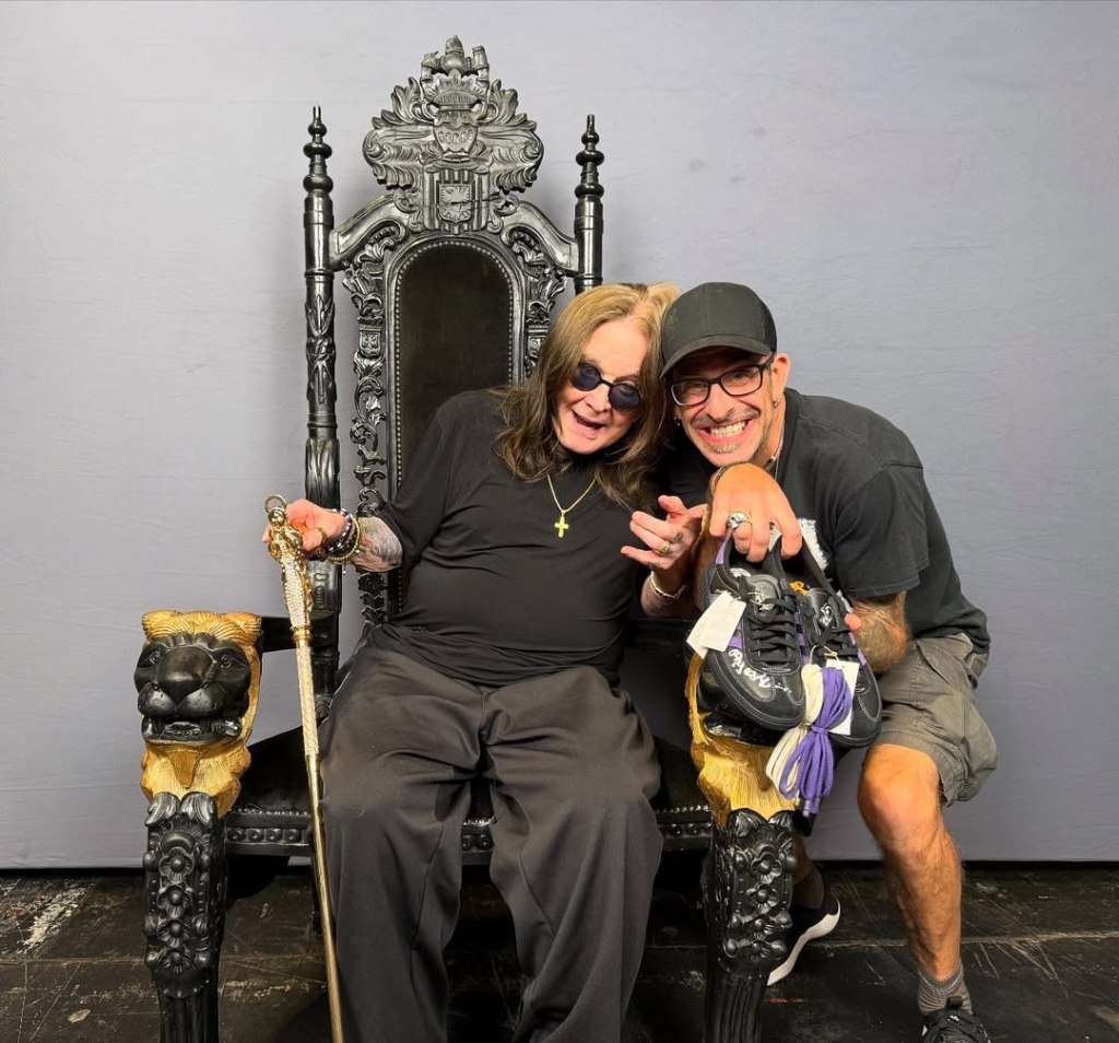 Ozzy Osbourne and another man sitting on a throne, showing off a pair of shoes.