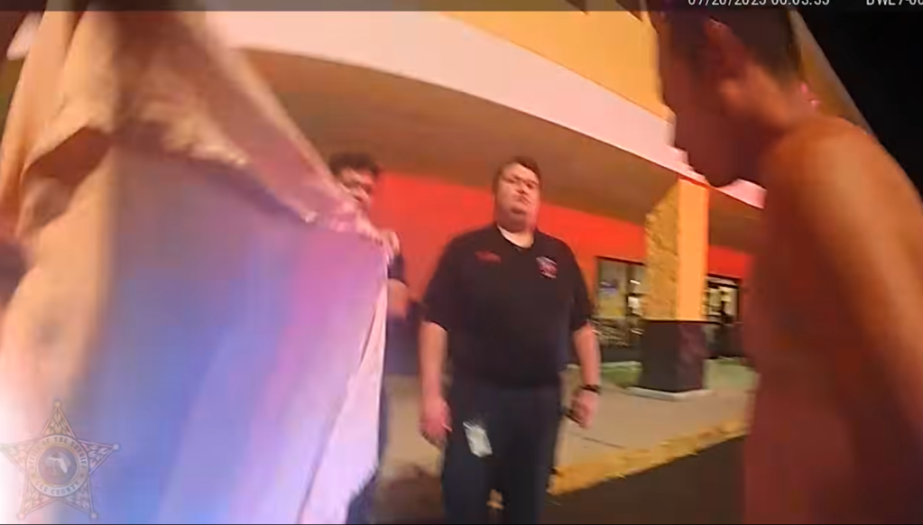 Antunez-Avarad is wrapped in a towel outside the Planet Fitness before being placed inside a squad car during his arrest.