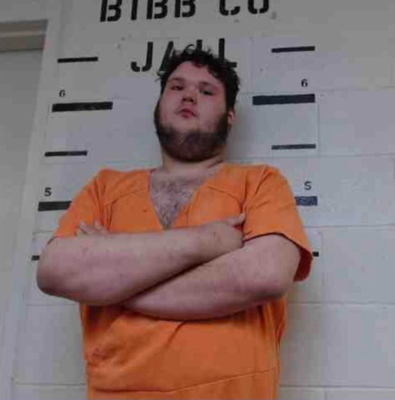 Mugshot of a man in an orange jumpsuit.