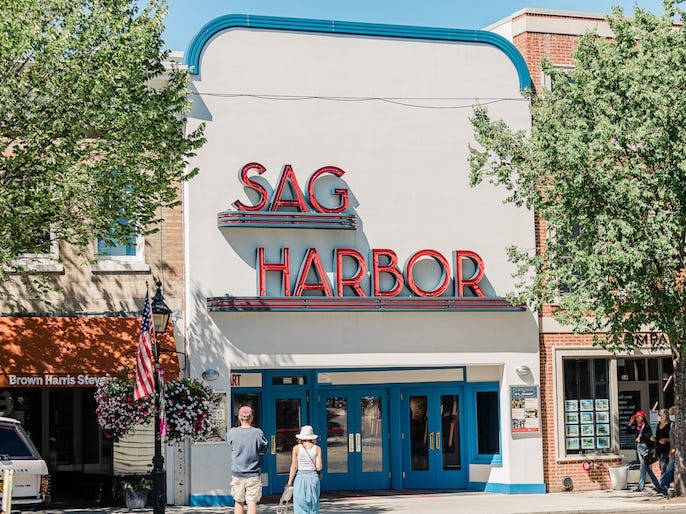 A cinema with a giant neon sign that reads "Sag Harbor."