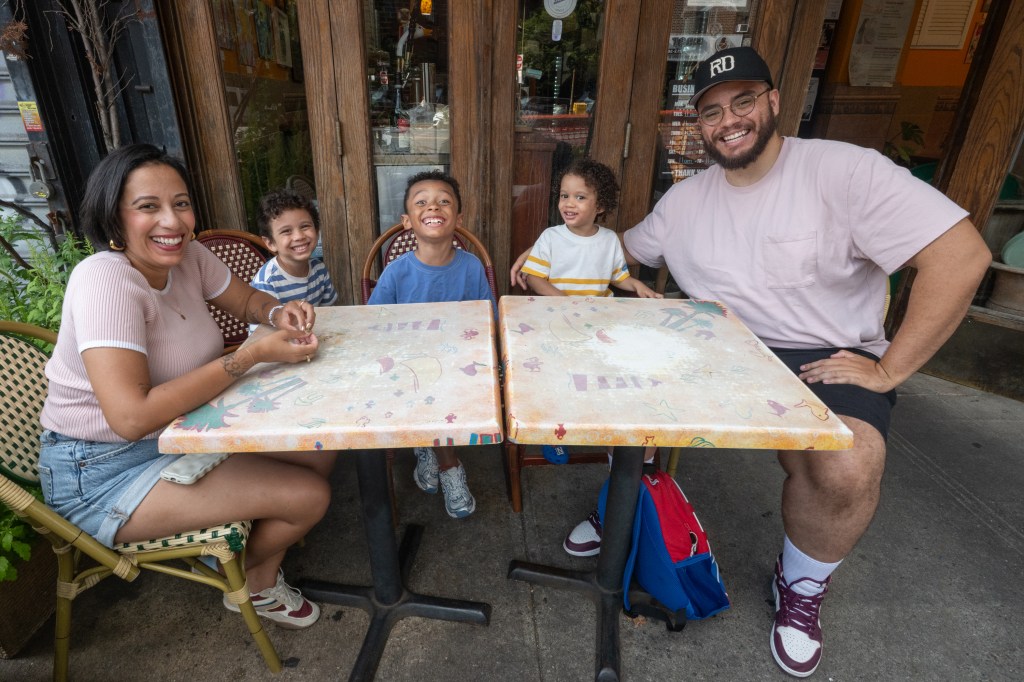 Rosdaly Ramirez (front) with her husband and children at an outdoor pizza restaurant. 