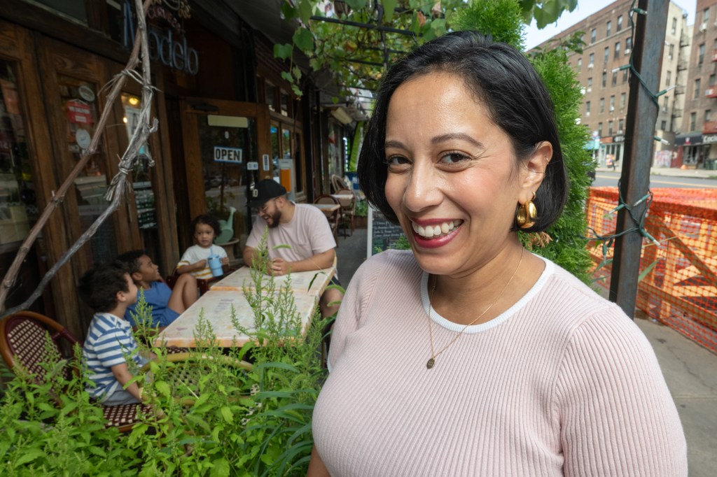 Rosdaly Ramirez (front) with her husband and children at an outdoor pizza restaurant.