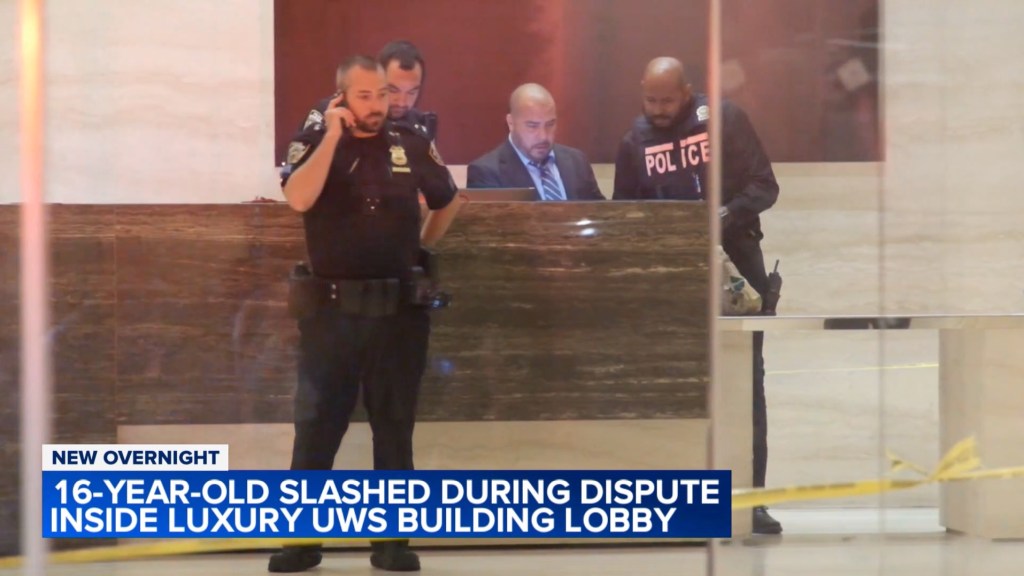 Police officers in a building lobby following a stabbing.