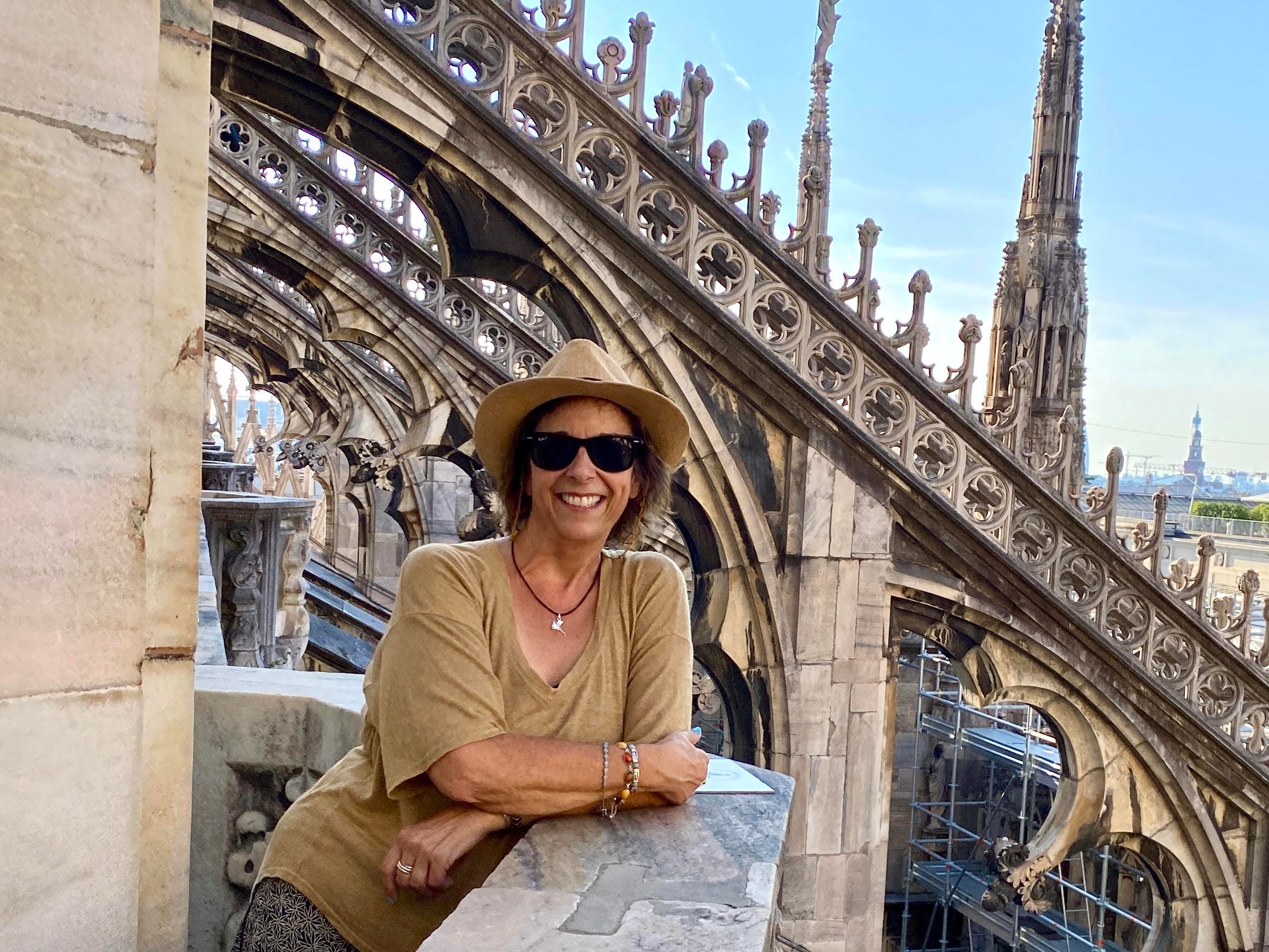 Cindy Sheahan leaning on a rooftop terrace of the Duomo di Milano in Milan.