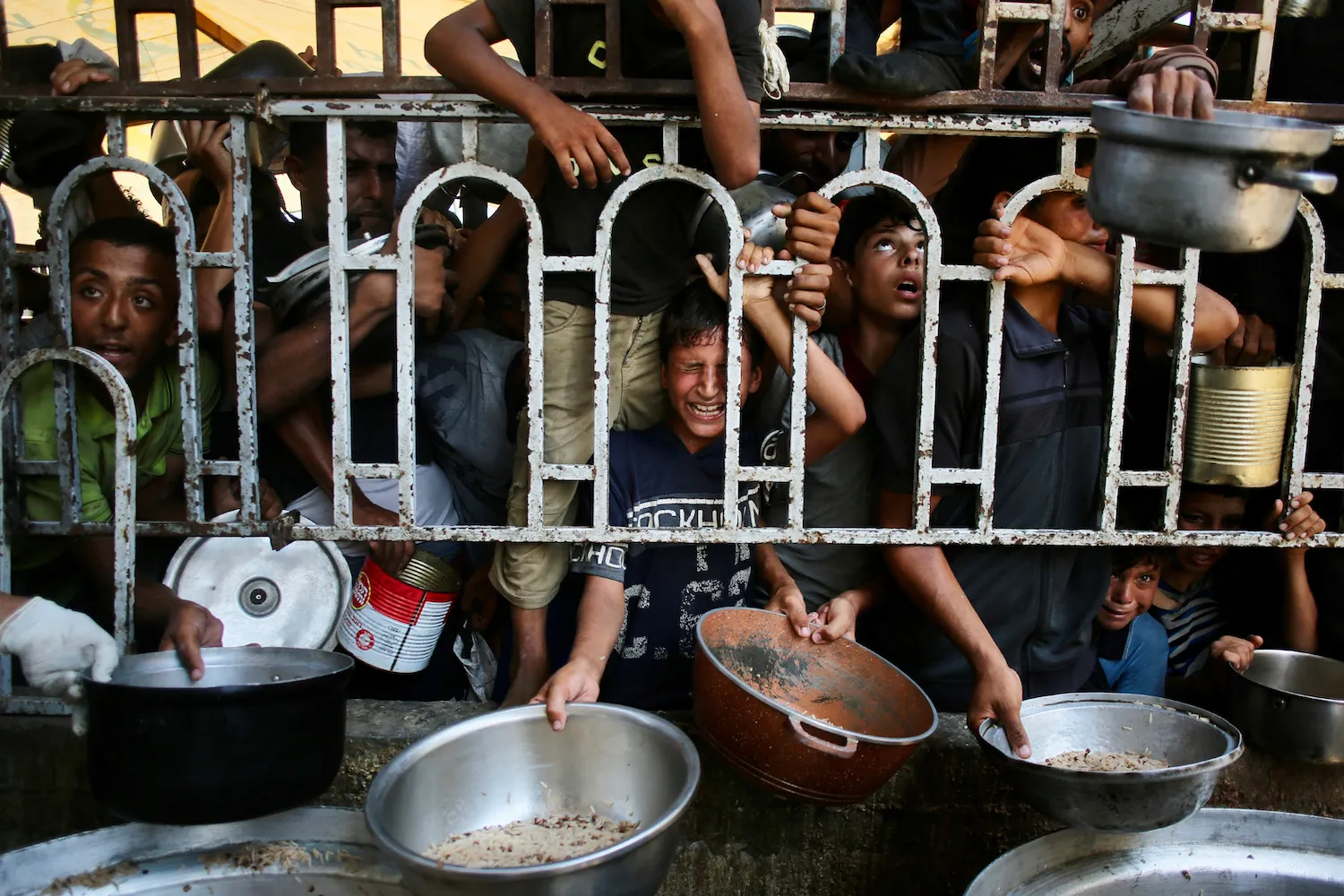Palestinian children wait for a meal at a charity kitchen in the Mawasi area of Khan Yunis in the southern Gaza Strip on July 22.