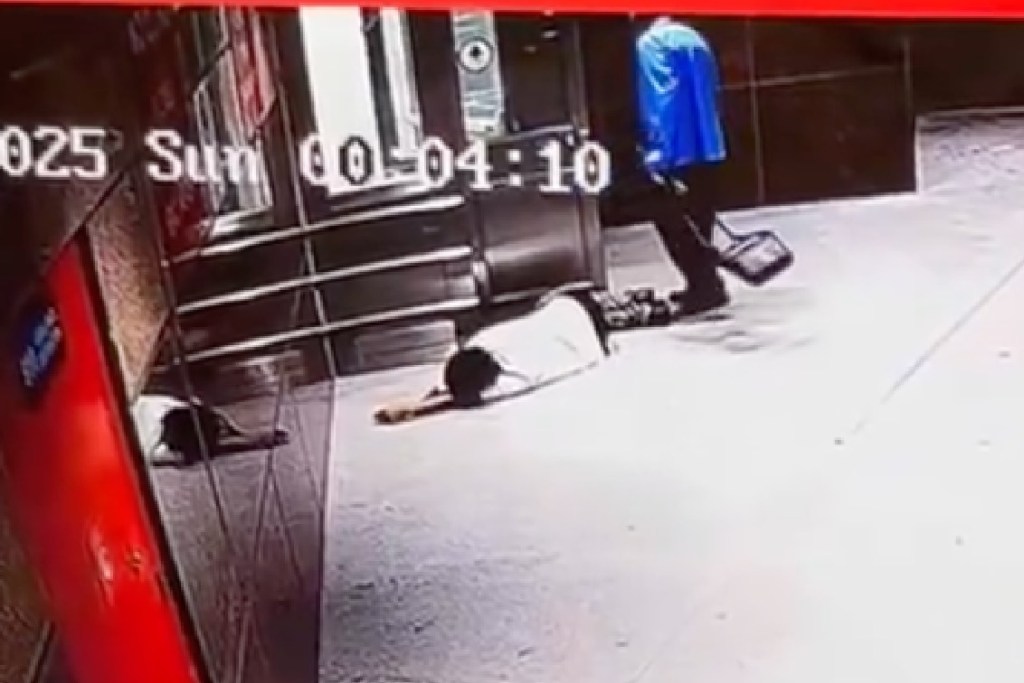 Video grab showing a person lying on the ground and another person walking away.