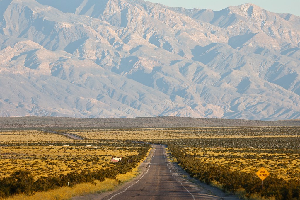 Desert road leading to mountains.