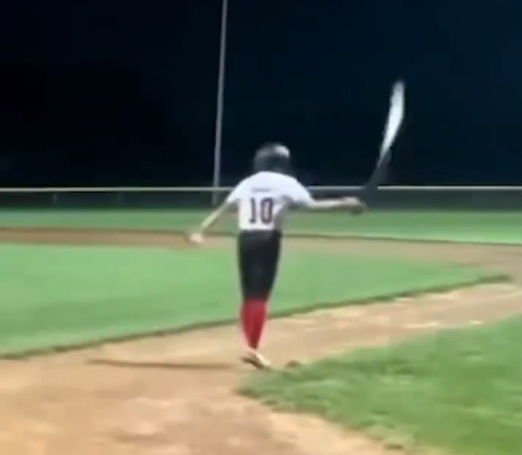 Little league baseball player flipping his bat.