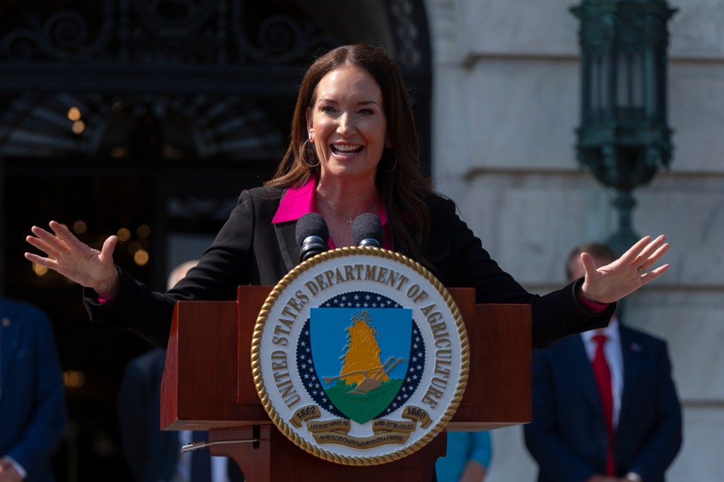 Brooke Rollins speaking at a podium with the USDA seal.